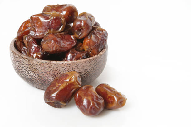 istock Dried dates in small bowl - studio shoot on the white 697454650