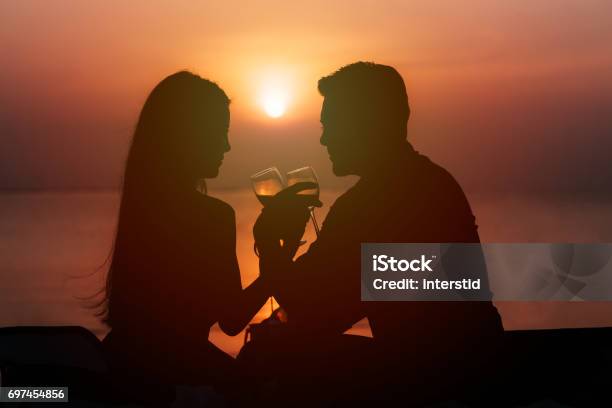 Silhouette Of Couple In Love Drinking Wine During Romantic Dinner Stock Photo - Download Image Now