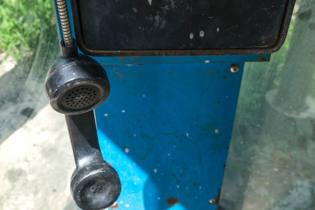 Hanging old phone receiver in old phone booth