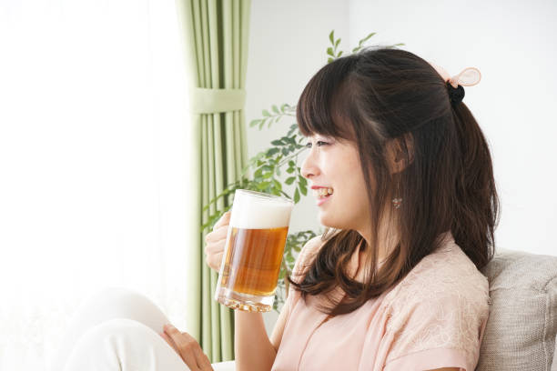 istock Young woman drinking beer at home 697459906