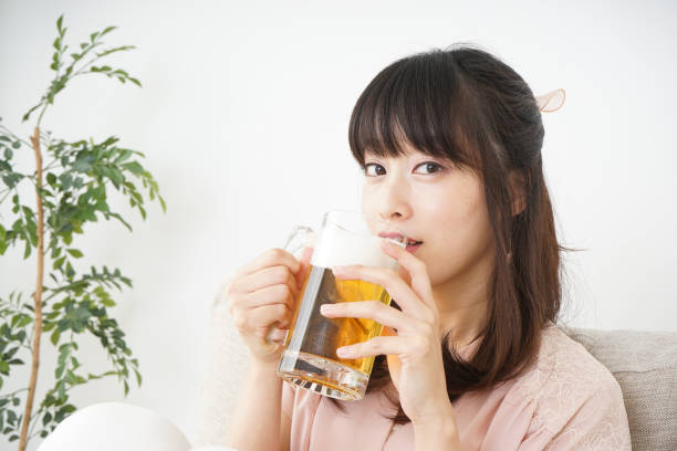 istock Young woman drinking beer at home 697459910