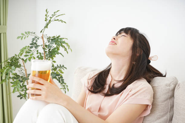 istock Young woman drinking beer at home 697459912