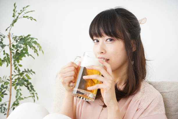 istock Young woman drinking beer at home 697459918