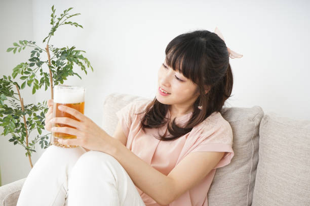 istock Young woman drinking beer at home 697459920