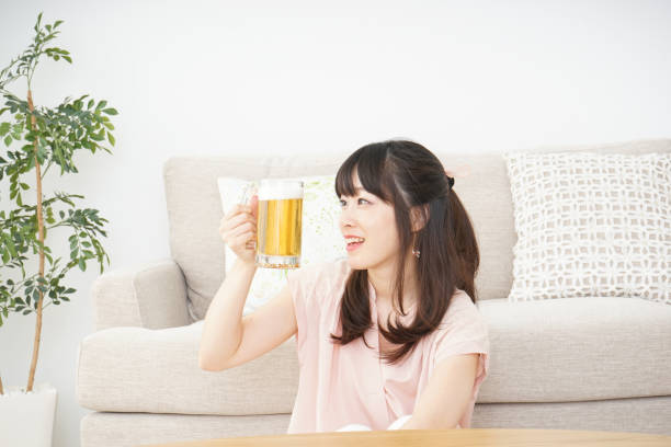 istock Young woman drinking beer at home 697459922