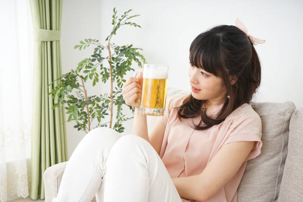 istock Young woman drinking beer at home 697459942