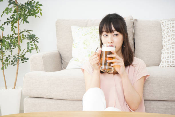istock Young woman drinking beer at home 697459946