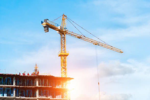 istock Crane and building construction site against blue sky 697462220