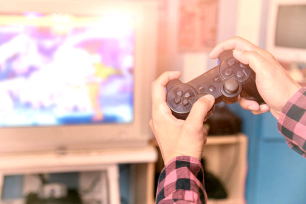 istock Closeup of male  playing video games at home; controller video console playing player holding. 697472320