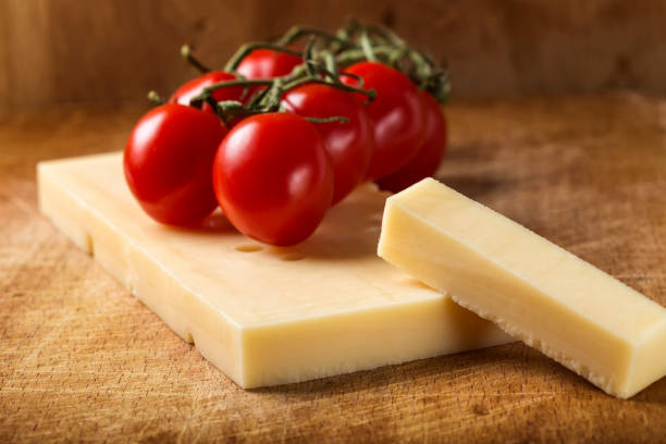 emmentaler käse mit cherry-tomaten auf holzbrett - cheese emmental cheese swiss culture cutting board stock-fotos und bilder