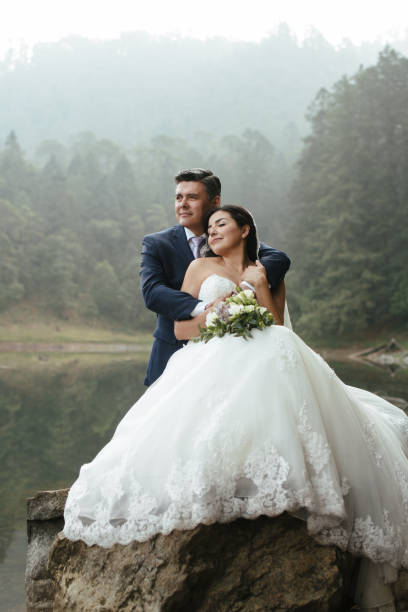 istock Serene bride and groom on a rock outdoors 697492756