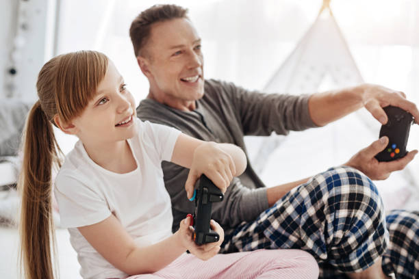 istock Engaged emotional child and her father using controllers for playing 697492822