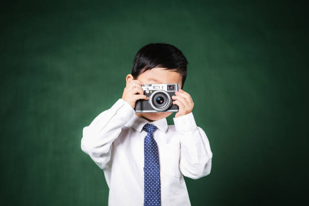 istock Little boy taking photos in the park 697493306