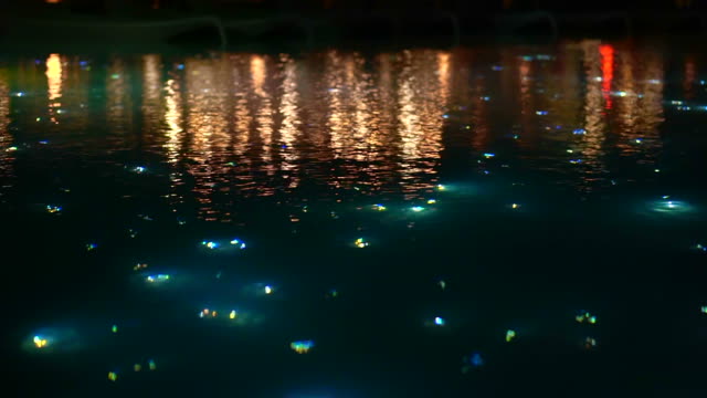 Blur beautiful light of starry night pool, illuminate fiber optic light next to restaurant