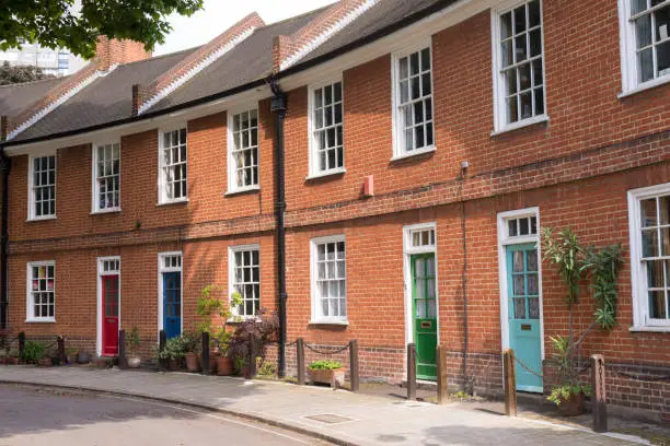 Photo of Restored Victorian red brick houses with colored doors on a local road in London, UK