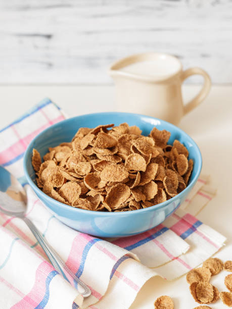 Wheat buckwheat bran breakfast cereal with milk in ceramic bowl Healthy breakfast with wheat buckwheat bran cereal with milk in blue ceramic bowl. Ready to eat bran flakes stock pictures, royalty-free photos & images