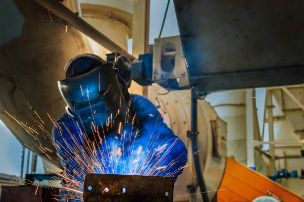 istock worker is welding in factory with protective mask 697517234
