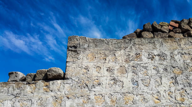 istock Ancient of block stone wall against blue sky 697517272