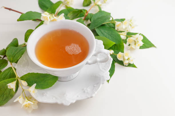 istock Cup of tea with jasmine flowers on a white table 697517734