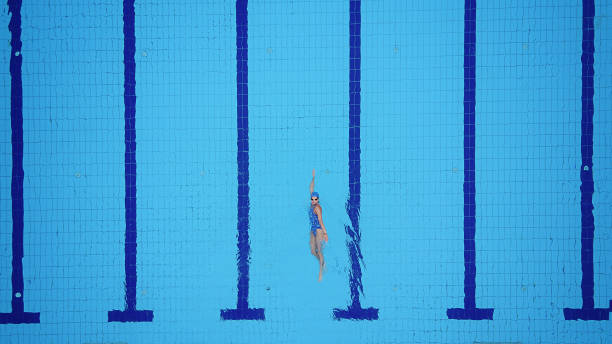 drohne sicht auf pool und weibliche rücken schwimmer - gegen den strom fotos stock-fotos und bilder