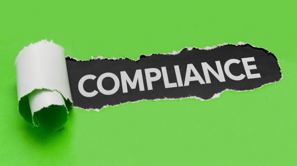 istock Torn green paper revealing the word Compliance 697527848