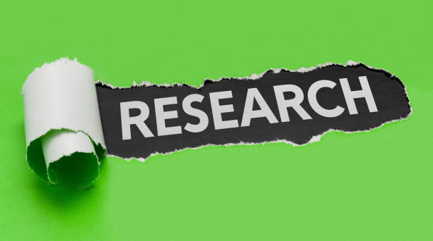 istock Torn green paper revealing the word Research 697528286