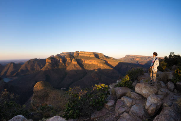Blyde River Canyon, travel destination in South Africa. Tourist looking at panorama. Last sunlight on the mountain ridges. Fisheye distorted view from above. Blyde River Canyon, travel destination in South Africa. Tourist looking at panorama. Last sunlight on the mountain ridges. Fisheye distorted view from above. blyde river canyon stock pictures, royalty-free photos & images