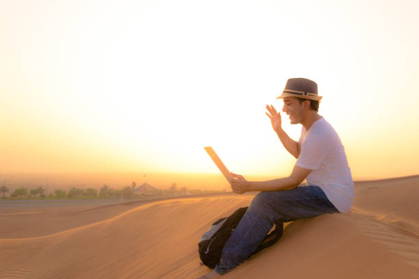 Teenage tourist in the Arabian desert with his smartphone