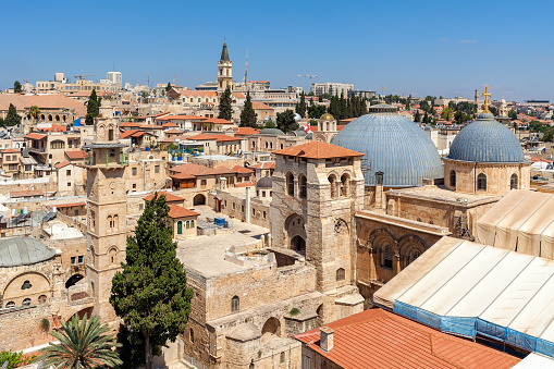 Church of the Holy Sepulchre domes, minarets and rooftops of the Old City of Jerusalem, Israel as seen from above.