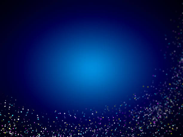 istock colorful twinkling glitter wave in front of a dark blue background with a blue oval highlight in the center 697548330