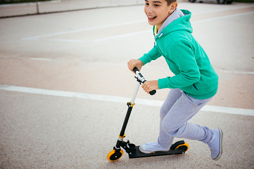 Photo of boy on a scooter in a park