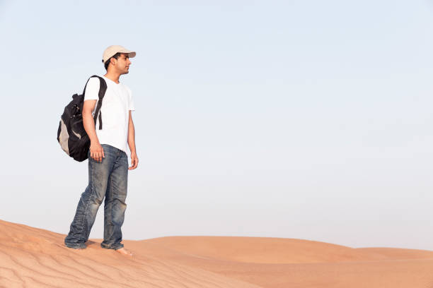 istock Teenager with his backpack exploring the dunes of Arabia 697555164