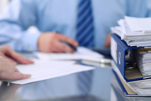 istock Binders with papers are waiting to be processed by bookkeepers back in blur. Accounting planning budget, audit, insurance  and business concept 697555240