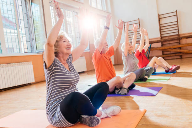 一緒にヨガをやって元気な高齢者のグループ - health club social gathering exercising sport ストックフォトと画像