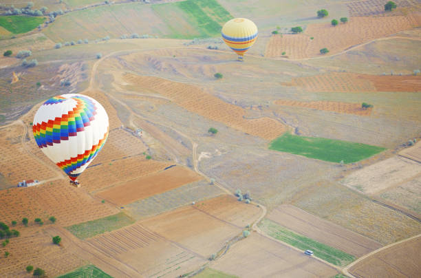 balão de ar voando acima da terra. foto horizontal - traditional festival adventure air air vehicle - fotografias e filmes do acervo