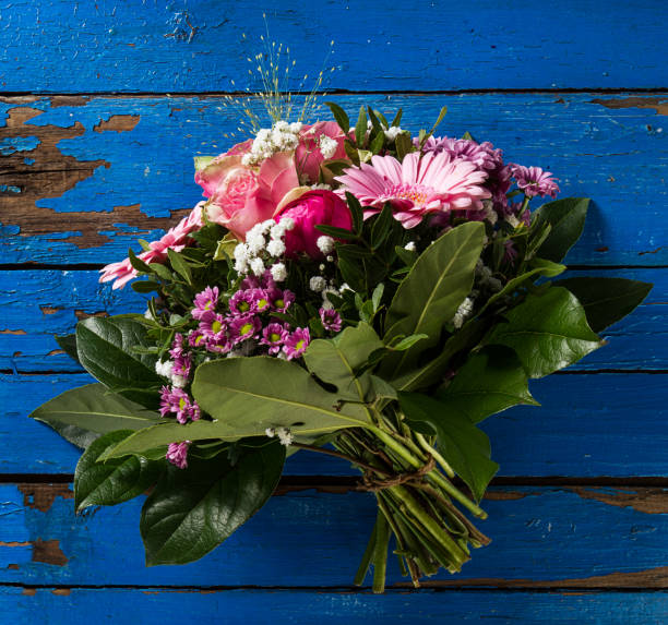 istock Beautifu pastel colors bouquet on blue rustic old table. Top View. 697566424