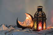 Lantern and a copper crescent shape on a satin cloth