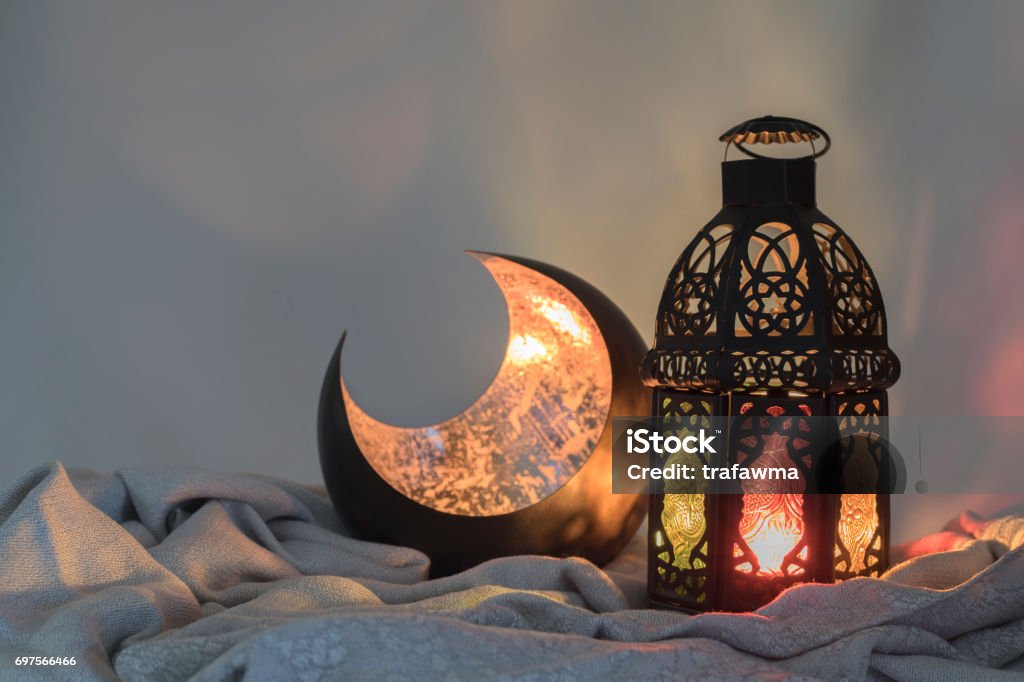 Lantern and a copper crescent shape on a satin cloth Eid-Ul-Fitr Stock Photo