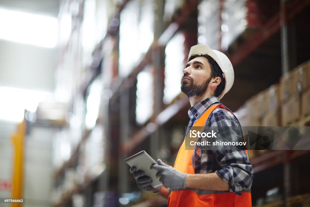 Revision of goods Worker with touchpad revising goods in storehouse Freight Transportation Stock Photo