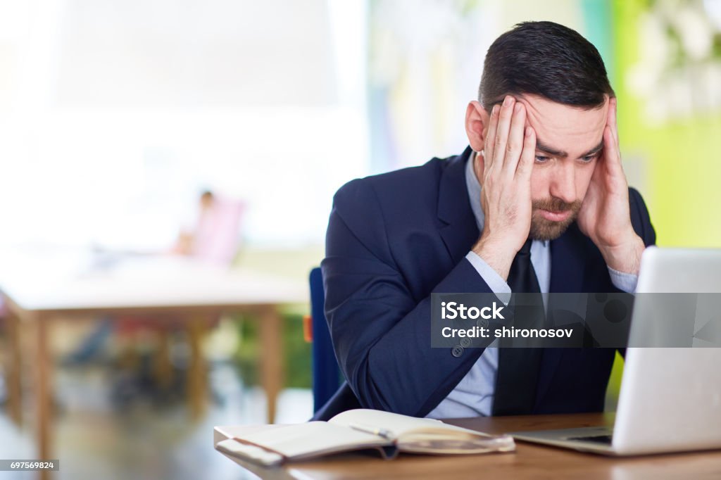 Tense man Businessman thinking of ideas in front of laptop Emotional Stress Stock Photo