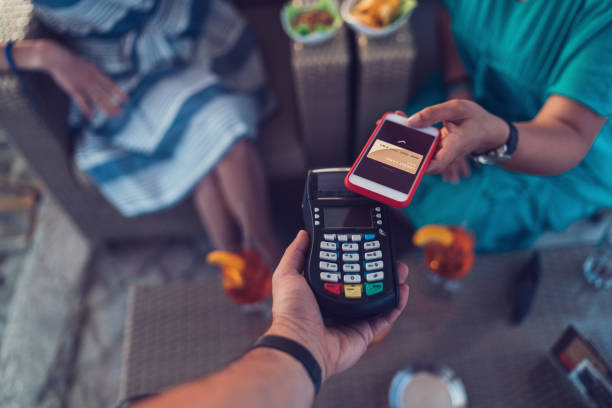 istock Friends in cafe paying contactless with smartphone 697573336