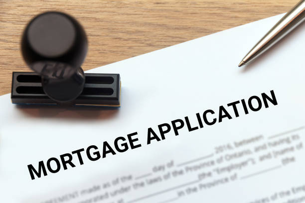 istock Mortgage application with rubber stamp on wooden desk. 697577172