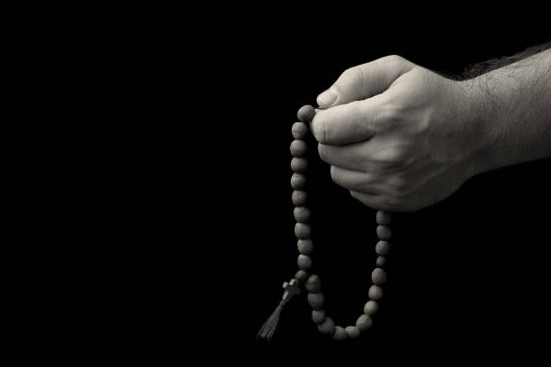 istock Rosary in male hands on a black background 697579976