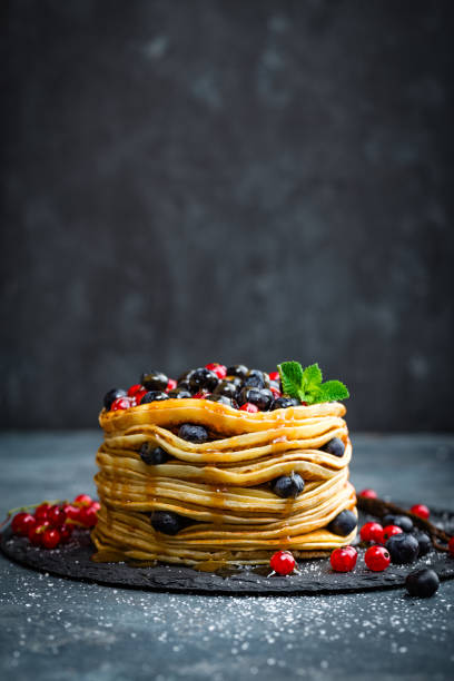 istock Pancakes with fresh berries and maple syrup on dark background, closeup 697587580