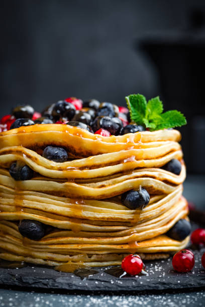 istock Pancakes with fresh berries and maple syrup on dark background, closeup 697587662