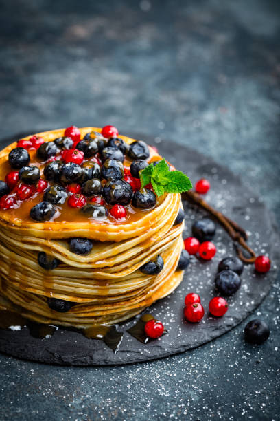 istock Pancakes with fresh berries and maple syrup on dark background, closeup 697587666
