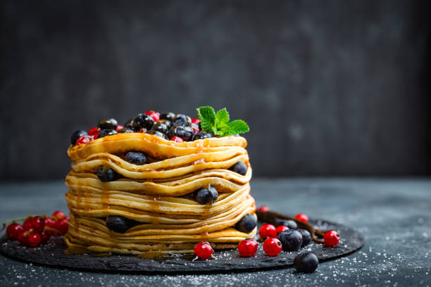 istock Pancakes with fresh berries and maple syrup on dark background, closeup 697587678