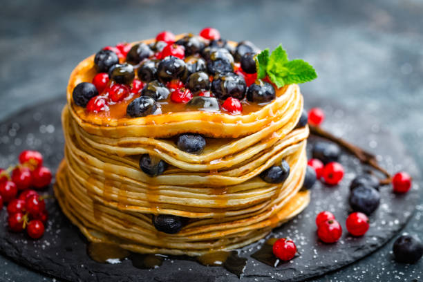 istock Pancakes with fresh berries and maple syrup on dark background, closeup 697587686