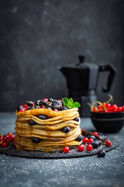 istock Pancakes with fresh berries and maple syrup on dark background, closeup 697587714