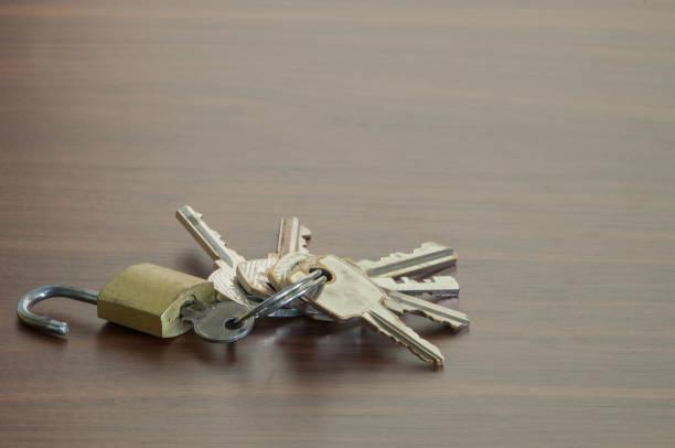 istock The small key lock on the wooden table,Keychain on the table background 697596200